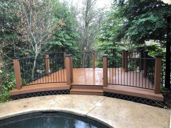 Custom Trex deck in Saddle in Redding,with hidden fasteners, custom railing, and black lattice skirting in a backyard.  Majestic Builders is proud to provide top quality composite decks that will last a lifetime.