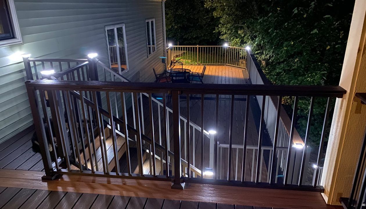 Two-Tone Low-Maintenance Trex Transcend Composite Deck with Black, Aluminum Railing and LED Lighting for Safety and Ambiance in the Rochester, MN Area built by Schmidt Carpentry, LLC
