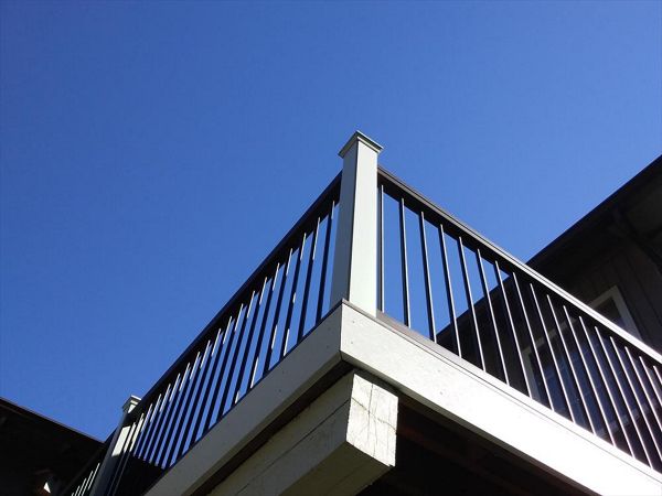 Trex Transcend composite rail in Vintage Lantern rail cap, black aluminum balusters, and white composite sleeves and caps.