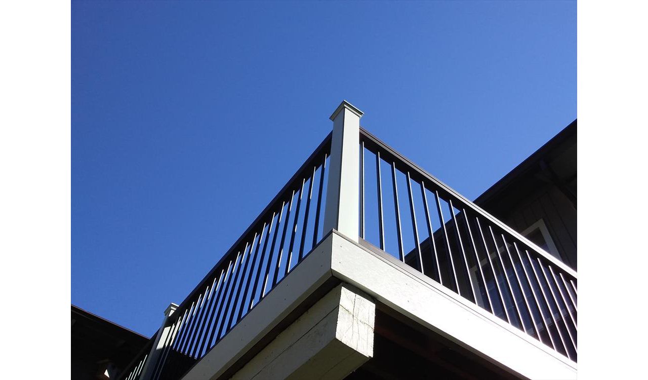 Trex Transcend composite rail in Vintage Lantern rail cap, black aluminum balusters, and white composite sleeves and caps.