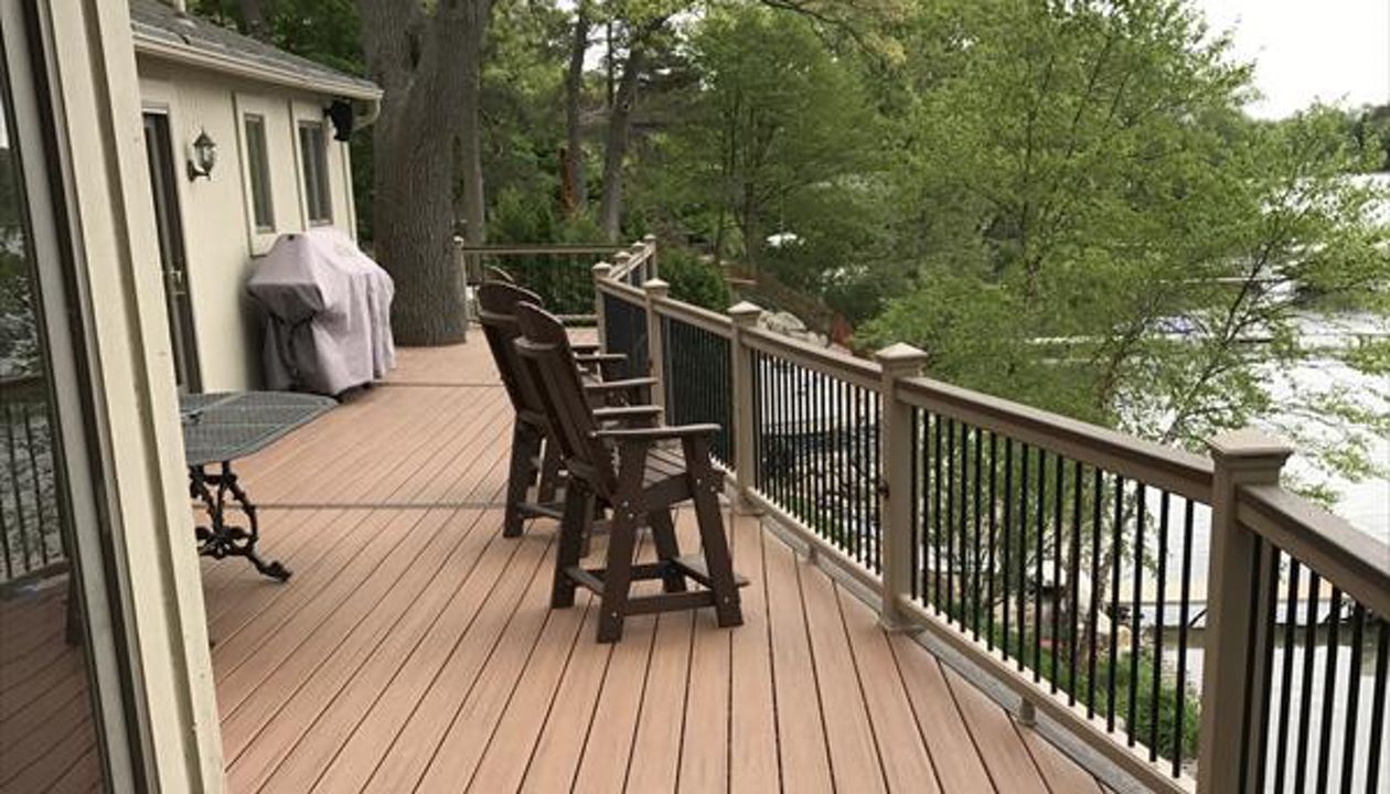 Deck on Middle Straits Lake in West Bloomfield, MI., constructed out of Trex Transcend Tropical decking in Tiki Torch / Spiced Rum; complimented by Trex Rope Swing railing w/ black balusters.