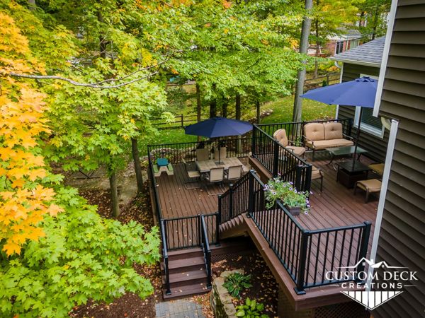 Multi-tiered Trex Transcend Lava Rock deck built with matching Lava Rock picture frame, fascia and composite lattice. Railing is black Trex Signature aluminum.