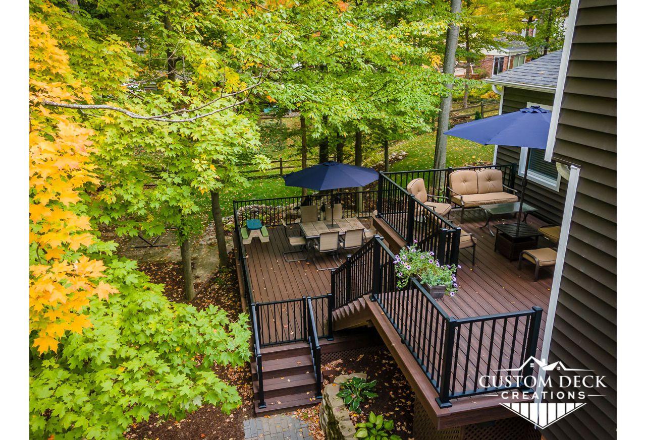 Multi-tiered Trex Transcend Lava Rock deck built with matching Lava Rock picture frame, fascia and composite lattice. Railing is black Trex Signature aluminum.
