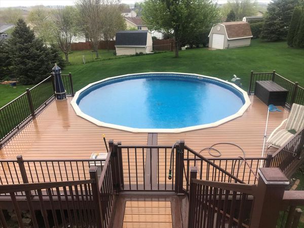 Trex Transcend Tiki Torch Decking around pool and Bronze Trex Signature Aluminum Railing with Trex Lighting in Rochester, MN