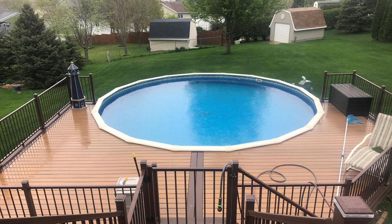 Trex Transcend Tiki Torch Decking around pool and Bronze Trex Signature Aluminum Railing with Trex Lighting in Rochester, MN