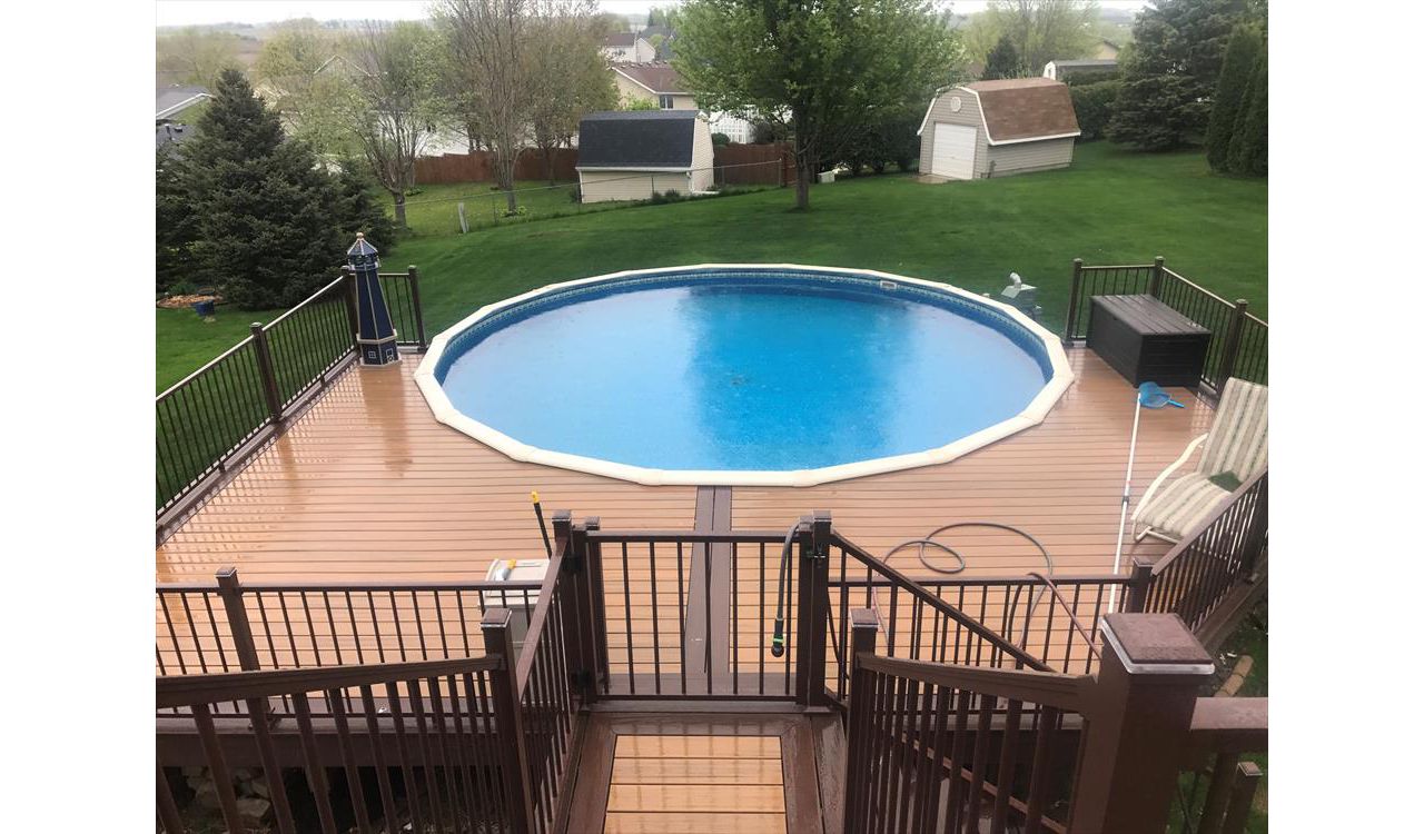 Trex Transcend Tiki Torch Decking around pool and Bronze Trex Signature Aluminum Railing with Trex Lighting in Rochester, MN