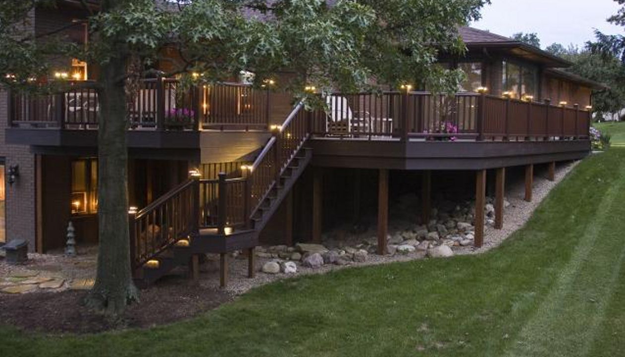 Wrap around deck featuring Trex Transcend Vintage Lantern decking with Trex Vintage Lantern Transcend Railing. Low-voltage LED Trex cap lights sets this deck off for a magnificent display at night.