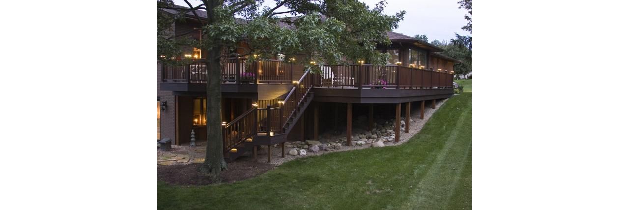 Wrap around deck featuring Trex Transcend Vintage Lantern decking with Trex Vintage Lantern Transcend Railing. Low-voltage LED Trex cap lights sets this deck off for a magnificent display at night.
