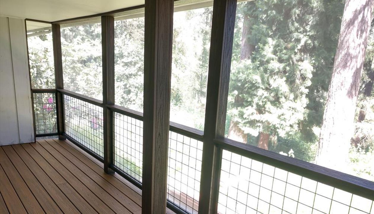 Trex Savanna Gold Decking, Lava Rock post wraps, on a screened in deck.