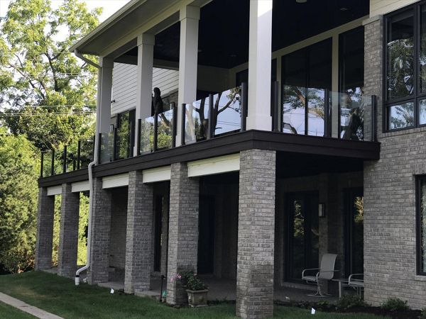 This deck has Goliath Tech helical piers. It also has spiced rum decking and a custom Trex transcends glass rail. The glass rail really makes this Trex deck look sharp.