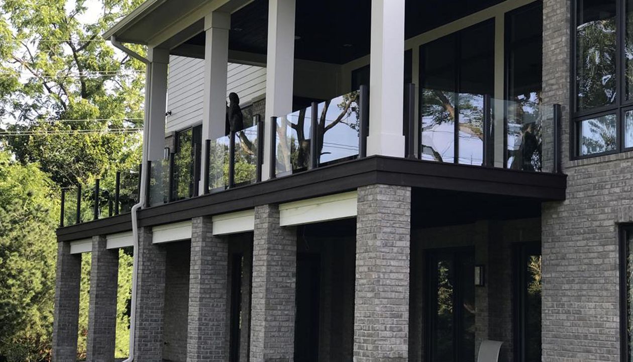 This deck has Goliath Tech helical piers. It also has spiced rum decking and a custom Trex transcends glass rail. The glass rail really makes this Trex deck look sharp.