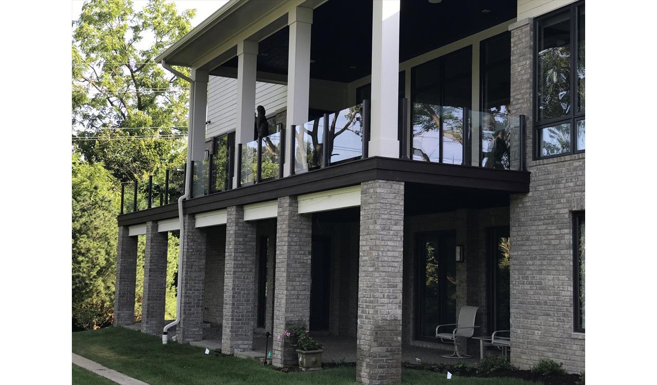 This deck has Goliath Tech helical piers. It also has spiced rum decking and a custom Trex transcends glass rail. The glass rail really makes this Trex deck look sharp.