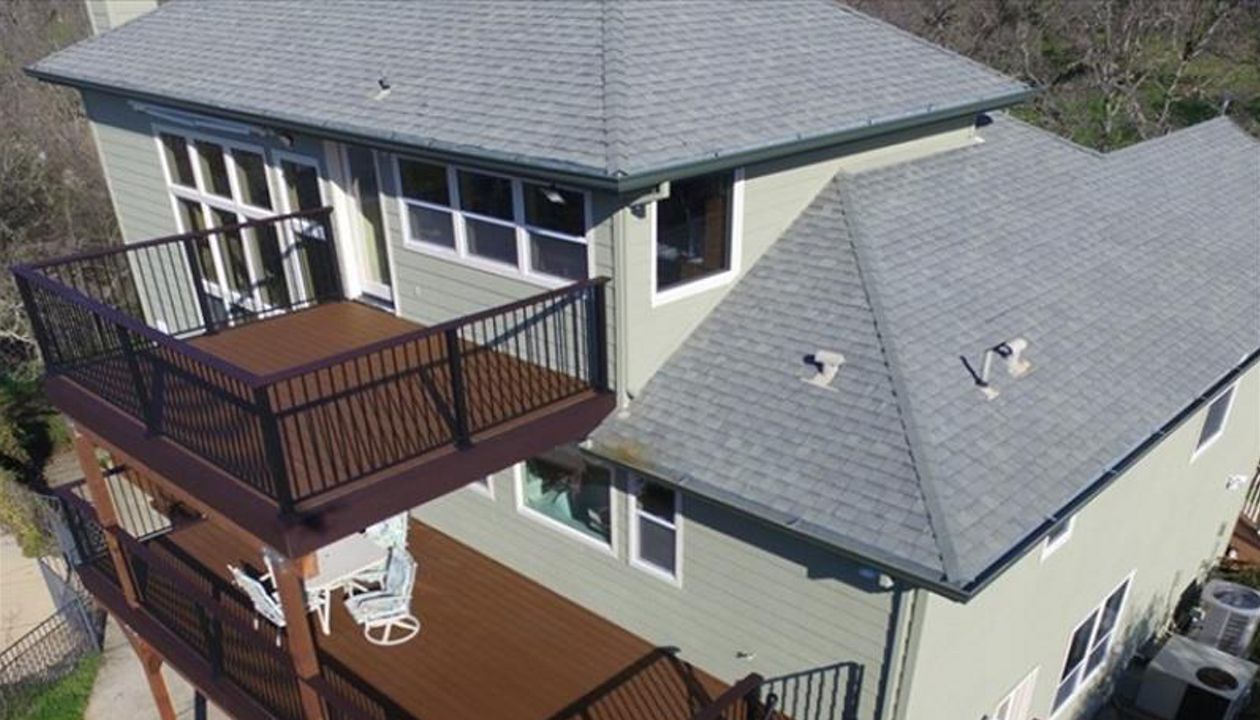 Three tiered custom Trex Deck in Saddle, Black Transcend Railing with Cocktail top rails.