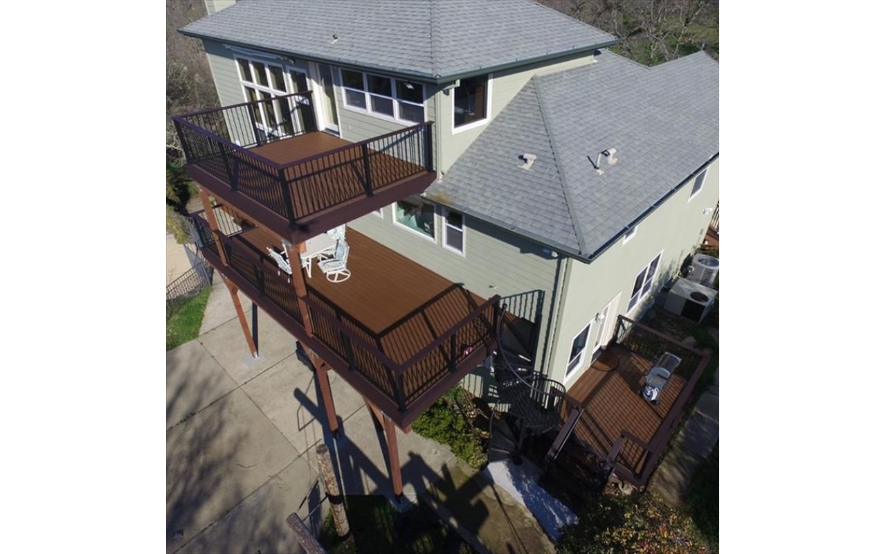 Three tiered custom Trex Deck in Saddle, Black Transcend Railing with Cocktail top rails.