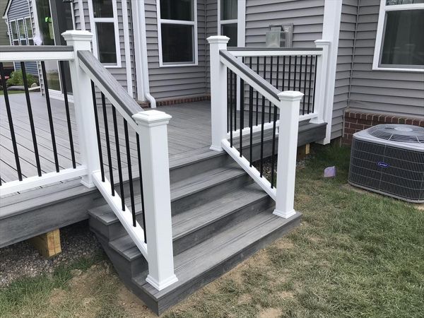 Deck in New Hudson, MI., constructed out of Trex Transcend Tropical decking in Island Mist and complimented by Classic White Trex railing with black balusters and Classic White privacy wall.