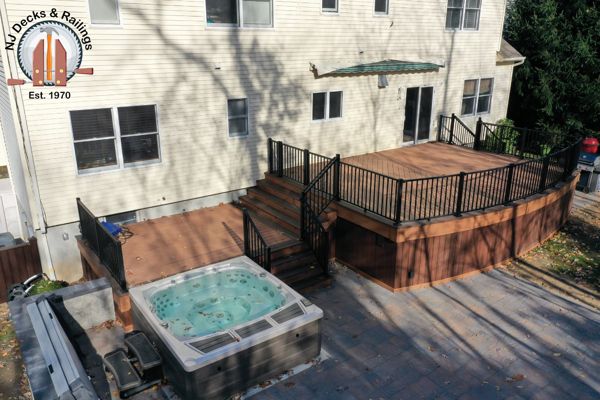 Curved front deck with Trex Transcend Tiki Torch body and Lava Rock border with custom curved black Signature railings.