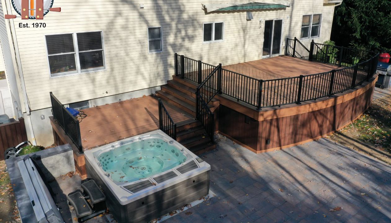 Curved front deck with Trex Transcend Tiki Torch body and Lava Rock border with custom curved black Signature railings.
