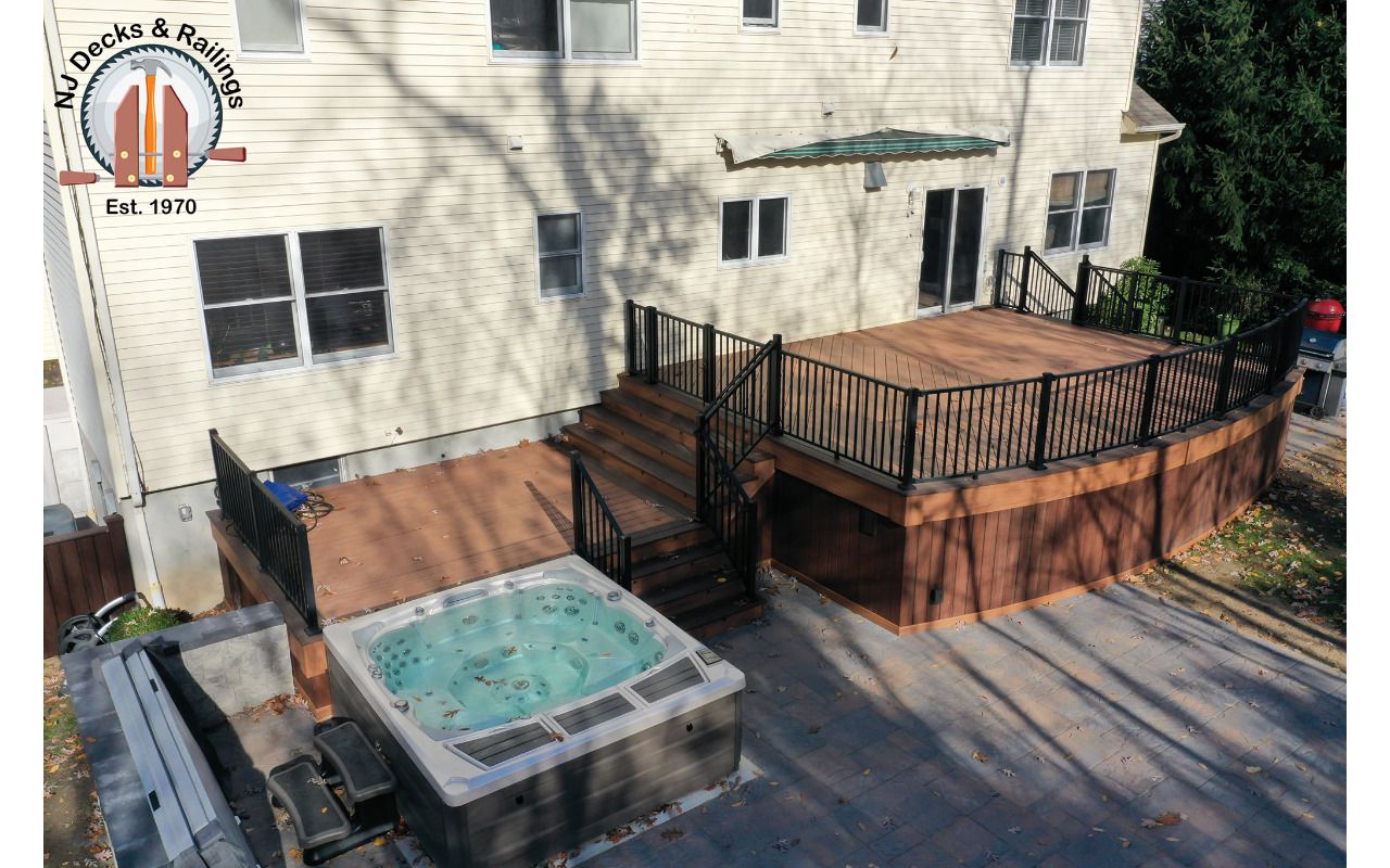 Curved front deck with Trex Transcend Tiki Torch body and Lava Rock border with custom curved black Signature railings.