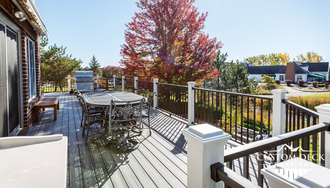 Trex Transcend Island Mist decking with Trex Signature aluminum railing in black, with Trex white railing posts