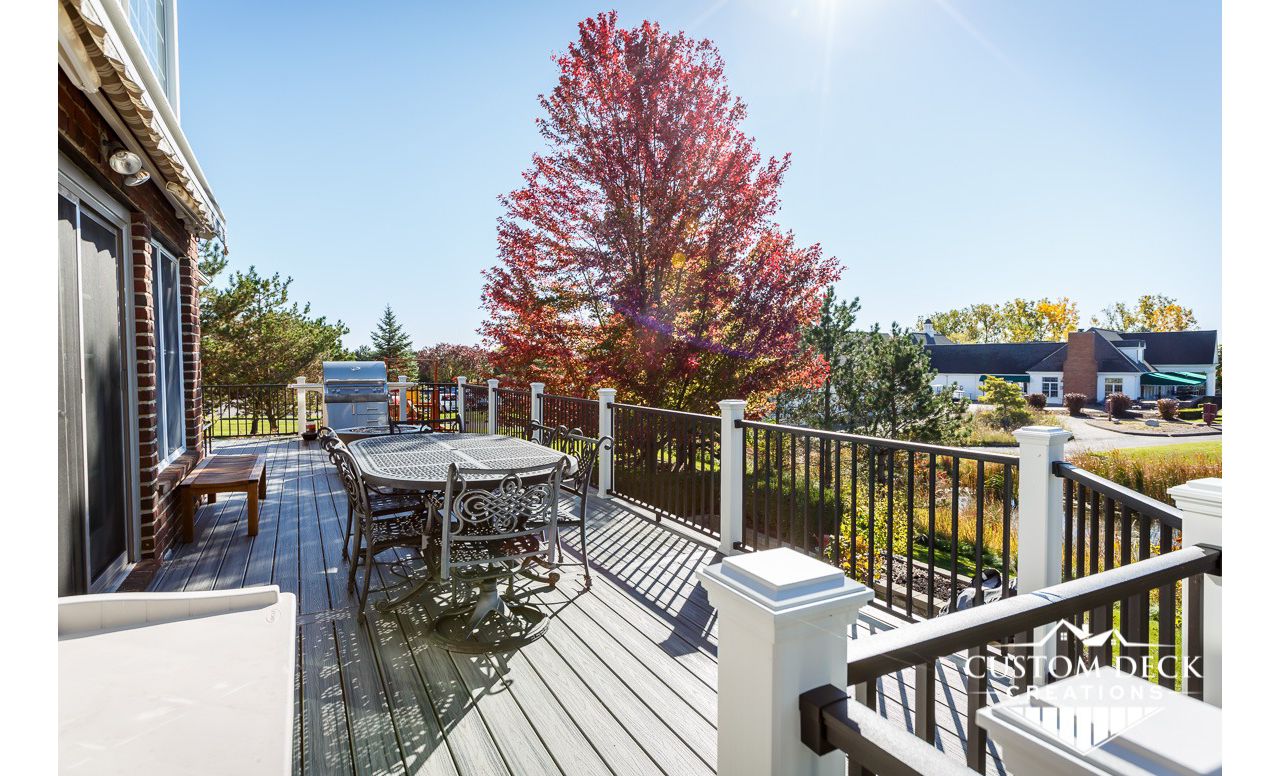 Trex Transcend Island Mist decking with Trex Signature aluminum railing in black, with Trex white railing posts