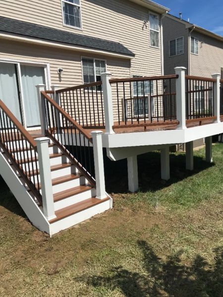 Tree House top and bottom railing. Black round aluminum balusters. TREX Select Saddle decking.