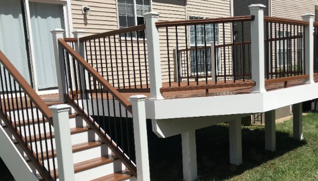 Tree House top and bottom railing. Black round aluminum balusters. TREX Select Saddle decking.