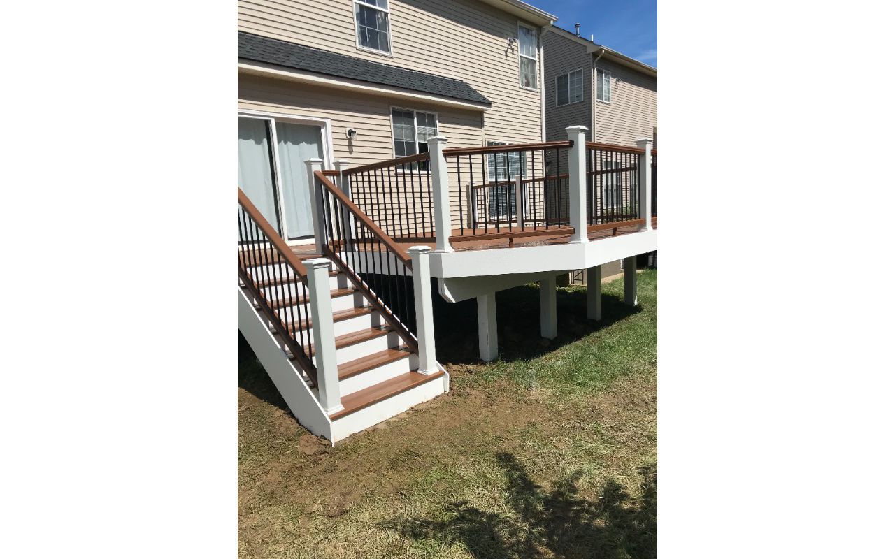 Tree House top and bottom railing. Black round aluminum balusters. TREX Select Saddle decking.