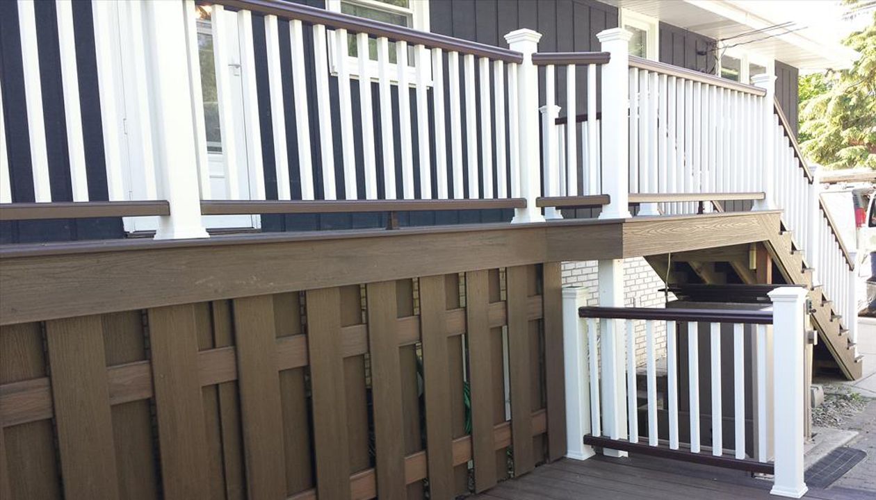Trex Transcend decking in Spiced Rum with a Vintage Lantern border. Railings have Vintage Lantern top and bottom rails with Classic White posts, caps and balusters.