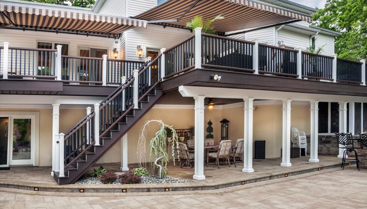 White post rail lights figuratively — and literally — brighten the darker undertones of this massive Manalapan, N.J., outdoor space done in both Spiced Rum (decking) and Vintage Lantern (border/fascia).