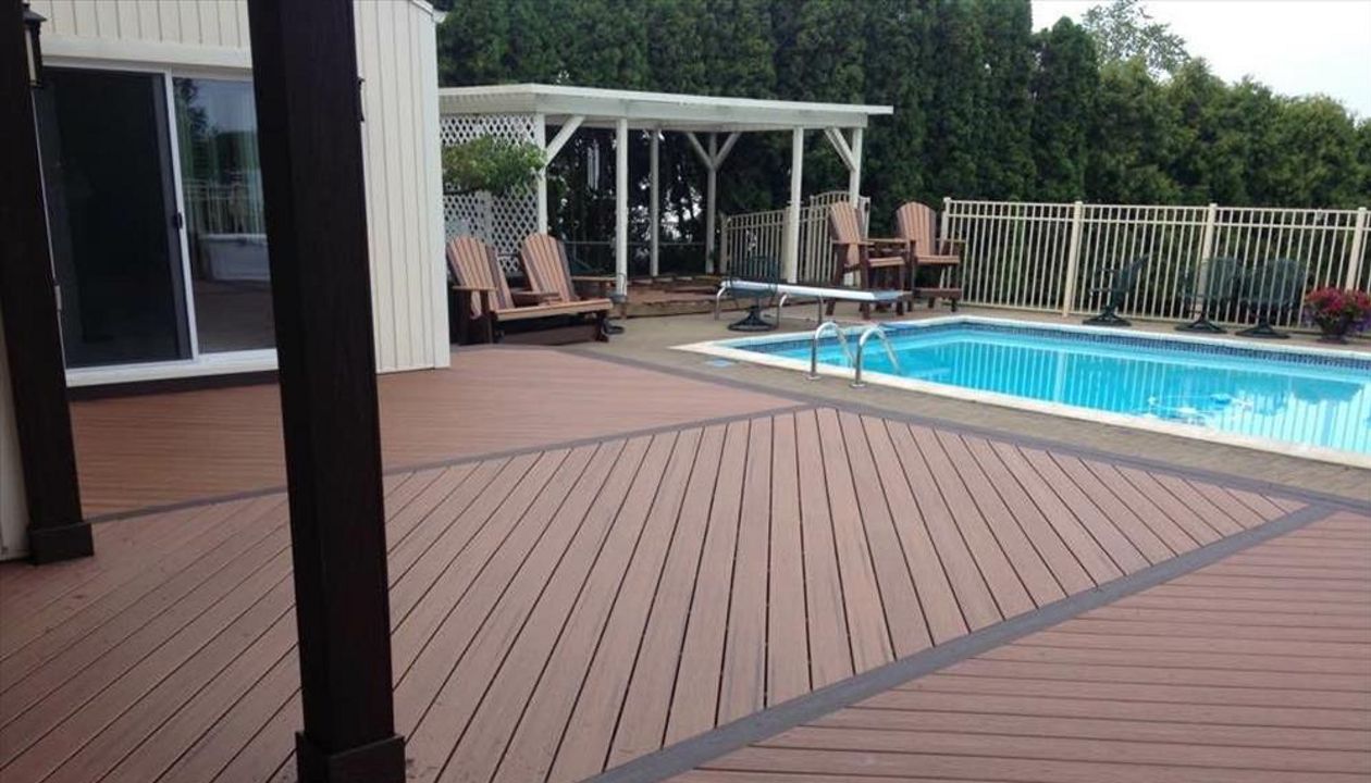 Wouldn't you like to relax on this pool deck?! This deck is made up of tiki torch Trex transcends decking and angled vintage lantern decking. Installed with Goliath Tech helical piers in Salem Township, MI.