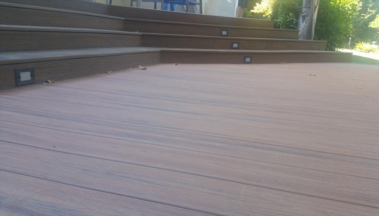 Custom Trex deck in Tiki Torch and Spiced Rum in Redding. Stairs have lighting and unique angles set to match the house.  Majestic Builders is proud to provide top quality composite decks that will last a lifetime.