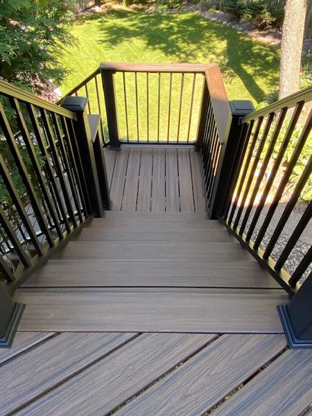 Trex/Transcend/Spiced Rum/Composite Decking with Trex/Signature/Aluminum Railing (black) between Trex/Composite Post Sleeves (black) and Trex/Transcend/Spiced Rum/Composite Decking/Drink Rail