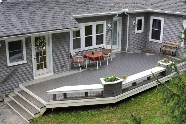Ground level deck featuring Trex Enhance Clam Shell decking with custom built in benches and flower pots.