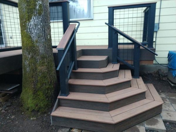 Custom designed sweeping staircase with Trex Transcend Cocktail Railings, Trex ADA handrails, Trex Savanna Gold decking, Lava Rock accents, wire infill rail panels