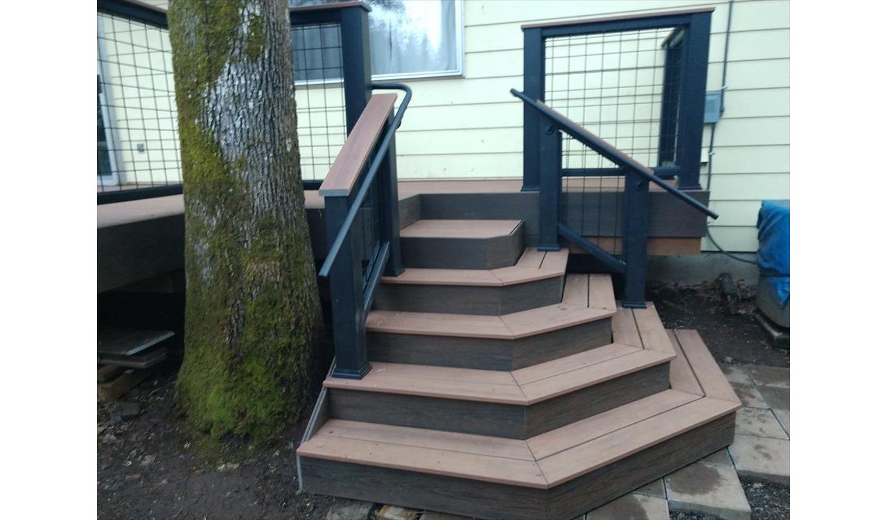 Custom designed sweeping staircase with Trex Transcend Cocktail Railings, Trex ADA handrails, Trex Savanna Gold decking, Lava Rock accents, wire infill rail panels