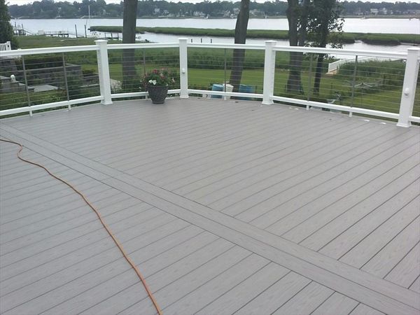 Trex Select Pebble Grey Decking  was used on this Trex Deck.  Cable Rail is stainless steel. Rain Escapes helped to create usable living space under the deck. Custom Lattice was used to create a storage space under the custom deck in Westport CT
