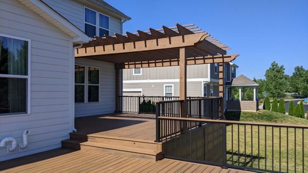 Trex Transcend Havana Gold, Signature rail in Charcoal Black, custom stained cedar pergola. Trex riser and flush mount lights.