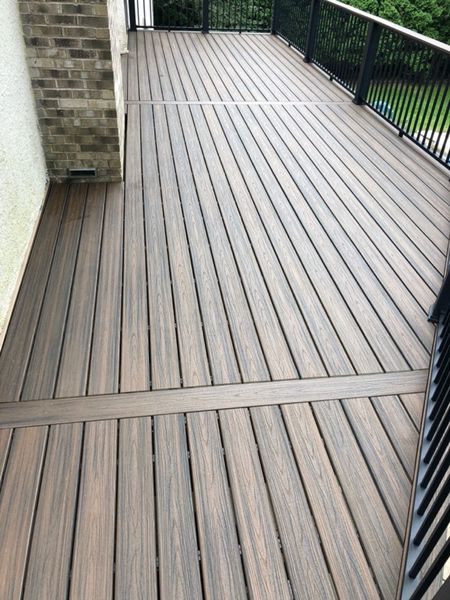 Trex/Transcend/Spiced Rum/Composite Decking with Trex/Signature/Aluminum Rail (black) between Trex Composite Post Sleeves (black) with Trex/Transcend/Spiced Rum/Cocktail Rail
