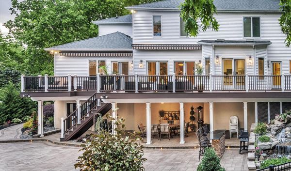A Trex Transcend railing runs the length of this magnificent deck in Manalapan, N.J., residence and is a piece of architectural art onto itself (Vintage Brown top/bottom with Square Black balusters).