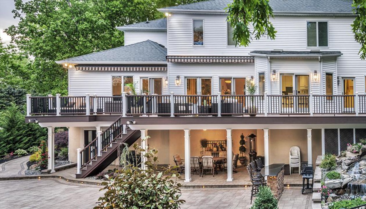 A Trex Transcend railing runs the length of this magnificent deck in Manalapan, N.J., residence and is a piece of architectural art onto itself (Vintage Brown top/bottom with Square Black balusters).