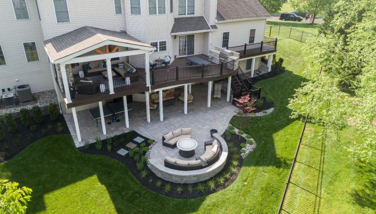 Trex Deck with Spiced Rum Decking, Trex Transcend Railing, Custom Curve, Roof, and Patio