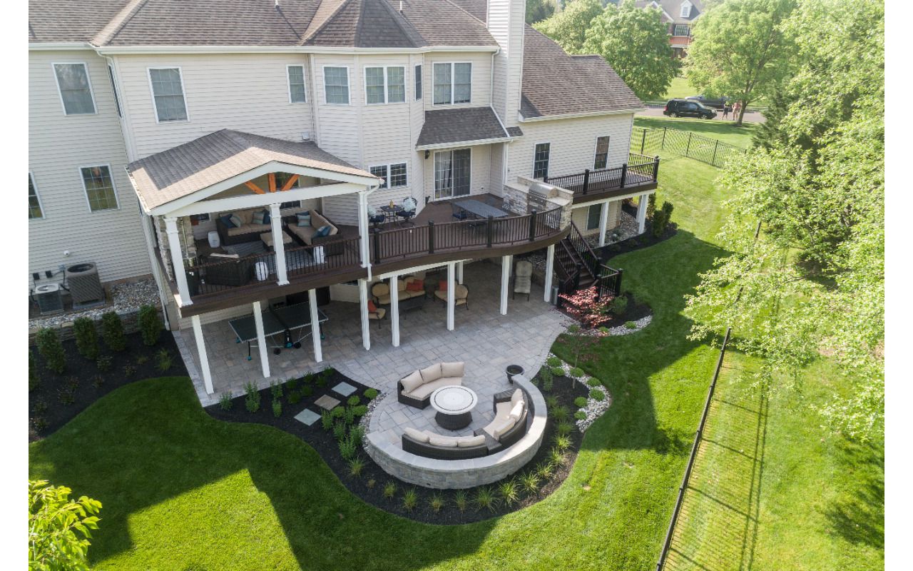 Trex Deck with Spiced Rum Decking, Trex Transcend Railing, Custom Curve, Roof, and Patio