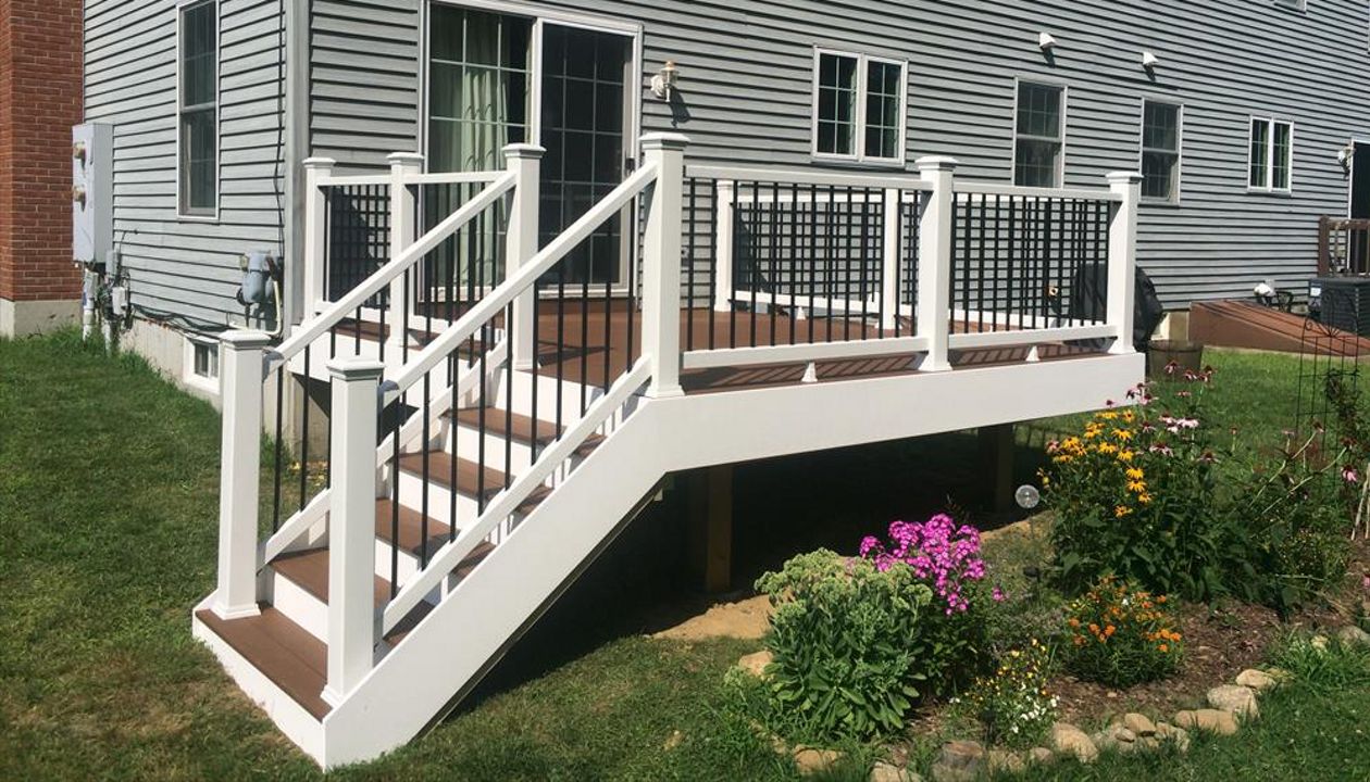 Select saddle decking, pvc trimboard risers and fascia, Trex enhance rails with black pipe balusters