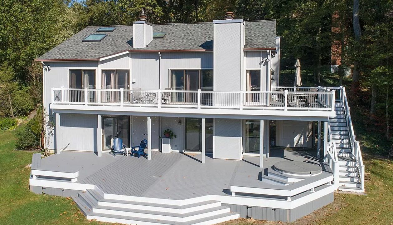 Trex Select Pebble Gray composite decking, white vinyl railing, gray round aluminum balusters, white fascia and vertical skirting