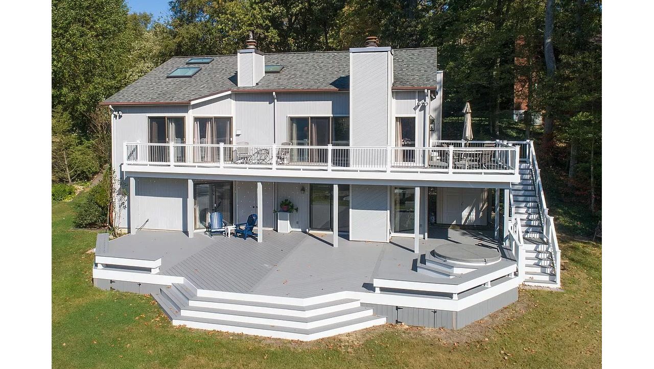 Trex Select Pebble Gray composite decking, white vinyl railing, gray round aluminum balusters, white fascia and vertical skirting