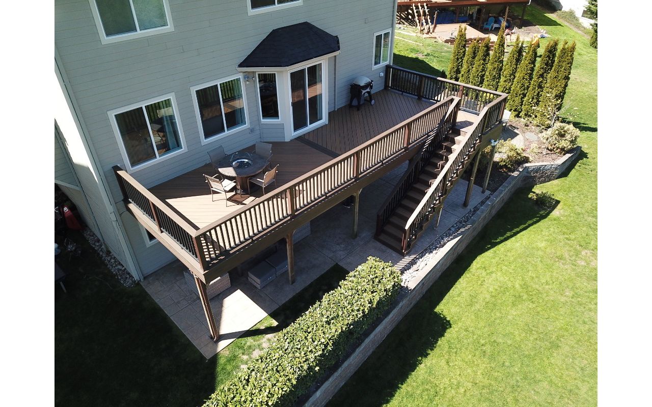 Camas, WA Trex Deck featuring Trex Havana Gold decking with Spiced Rum border. Trex Transcend railing in Vintage Lantern post with black infill with Trex LED lights