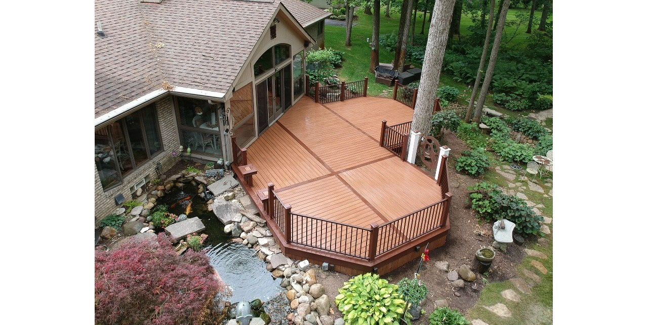 Trex Tiki Torch decking with a single Vintage Lantern border. Also including a Trex Signature Bronze railing with Vintage Lantern post sleeves.