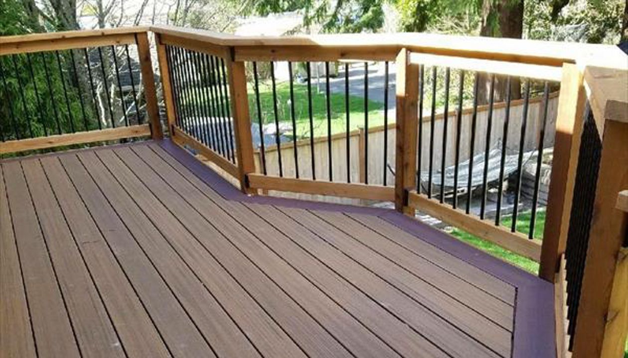 Trex Contour Torino Brown with Moroccan Red border, cedar rails and fascia, and black aluminum balusters.