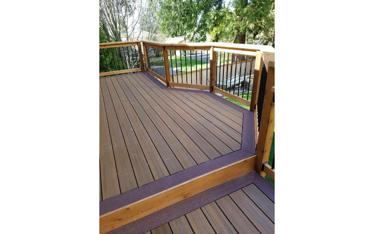 Trex Contour Torino Brown with Moroccan Red border, cedar rails and fascia, and black aluminum balusters.