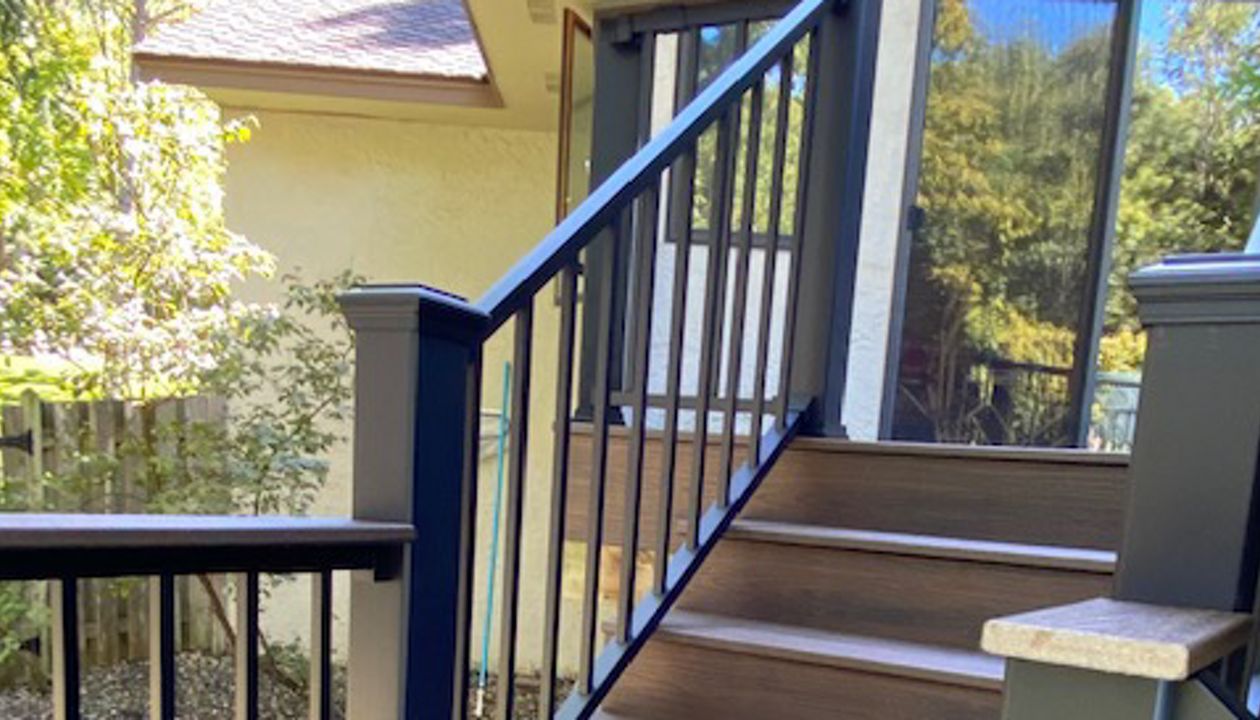 Trex/Transcend/Spiced Rum/Composite Decking with Trex/Signature/Aluminum Railing (black) between Trex Composite Post Sleeves and Trex/Transcend/Spiced Rum/Composite Decking for Cocktail Rail